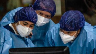 Nurses watch a computer screen in Bogota, Colombia on February 18, 2021.