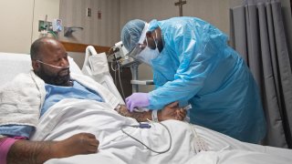 A nurse treats Covid-19 patient Cedric Daniels