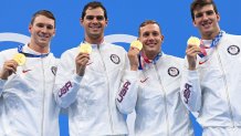 Gold medallists (from L) USA's Ryan Murphy, USA's Michael Andrew, USA's Caeleb Dressel and USA's Zach Apple pose on the podium after the final of the men's 4x100m medley relay swimming event during the Tokyo 2020 Olympic Games at the Tokyo Aquatics Centre in Tokyo on August 1, 2021.
