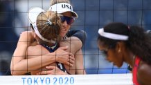 April Ross (C) and partner Alix Klineman celebrate winning, as Cuba's Lidianny Echevarria Benitez (R) walks past, after their women's beach volleyball round of 16 match between Cuba and the USA during the Tokyo 2020 Olympic Games at Shiokaze Park in Tokyo on August 2, 2021.