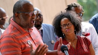 In this June 29, 2021, file photo, Boston Mayor Kim Janey listens as Tito Jackson speaks at a news conference hosted by a coalition of community leaders of black men at City Hall.