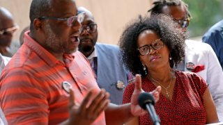 In this June 29, 2021, file photo, Boston Mayor Kim Janey listens as Tito Jackson speaks at a news conference hosted by a coalition of community leaders of black men at City Hall.