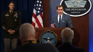 U.S. Department of Defense Press Secretary John Kirby (R) speaks as Army Major General William Taylor (L) listens during a news briefing