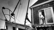 Phil Reynolds surveys the damage from a beached sailboat which crashed into his home on Penzance Point in Woods Hole, Mass., on Aug. 20, 1991, after Hurricane Bob.
