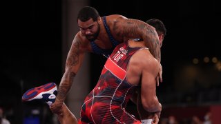An upright Gable Steveson has one arm around the nck of Turkey's Taha Akgul and a hand on his opponent's ankle