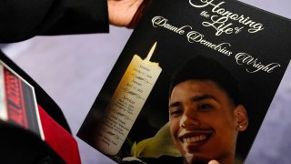 a mourner holds a program for the funeral services of Daunte Wright