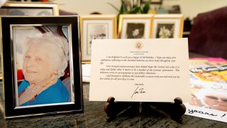 A note from President Joe Biden is seen placed among photos of Primetta Giacopini, who died of COVID-19 11 days prior in Richmond, Calif. on Monday, Sept 27, 2021. Primetta Giacopini's life ended the way it began — in a pandemic. She was two years old when she lost her mother to the Spanish flu in Connecticut in 1918. Giacopini contracted COVID-19 earlier this month. The 105-year-old struggled with the disease for a week before she died Sept. 16.