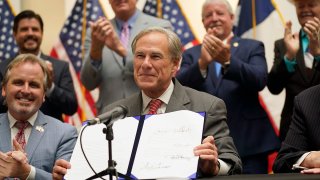 Texas Gov Greg Abbott holds up Senate Bill 1, also known as the election integrity bill, after he signed it into law in Tyler, Texas, Sept. 7, 2021. The sweeping bill signed Tuesday by the two-term Republican governor further tightens Texas’ strict voting laws.