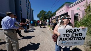 Anti-abortion activists gather for a small protest outside the Jackson Women's Health Organization clinic in Jackson, Miss.