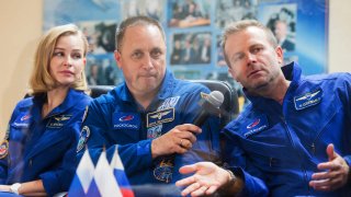 Actress Yulia Peresild, left, director Klim Shipenko, right, and cosmonaut Anton Shkaplerov, members of the prime crew of Soyuz MS-19 spaceship attend a news conference at the Russian launch facility