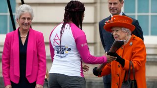 Britain's Queen Elizabeth II hands over the Queen's Baton to the first relay runner Kadeena Cox