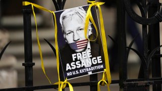 A poster of Julian Assange is fixed at the entrance gate outside the High Court in London