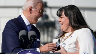 President Joe Biden, left, presents 2020 National Teacher of the Year Tabatha Rosproy, a preschool teacher from Kansas, with her award during an event for the 2020 and 2021 State and National Teachers of the Year on the South Lawn of the White House in Washington, Monday, Oct. 18, 2021.