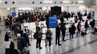 Travelers arrive for flights at Newark Liberty International Airport on November 30, 2021 in Newark, New Jersey.