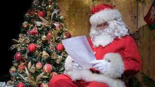 Alberto Barbi, dressed up as Santa Claus, reads letters before talking to children via video call at the Cinema Teatro Gobbetti on December 22, 2020 in San Mauro Torinese near Turin, Italy