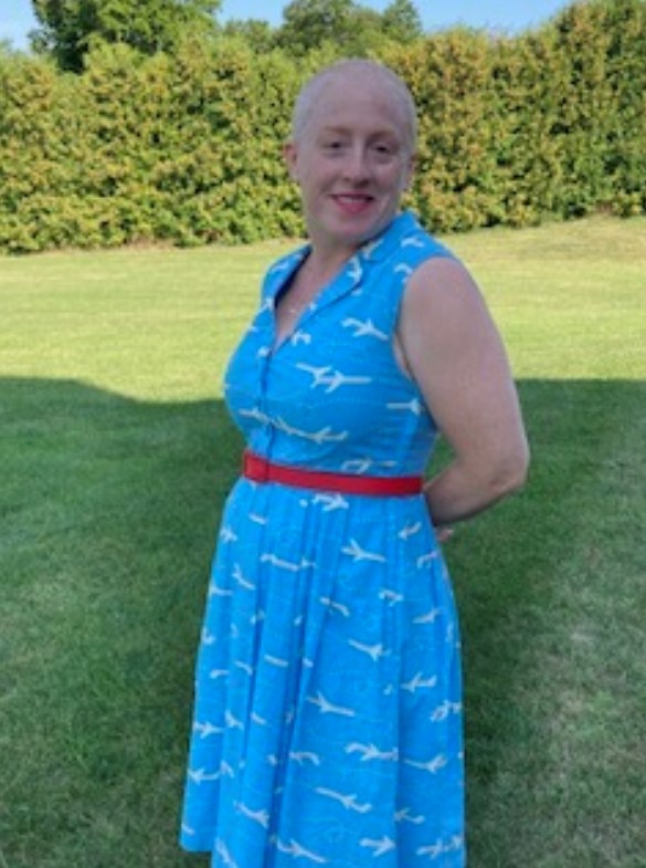 A lady in a blue dress poses for the camera