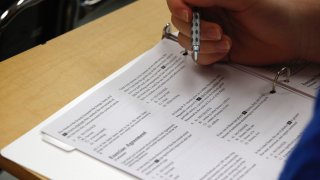 FILE - In this photo taken Jan. 17, 2016, a student looks at questions during a college test preparation class