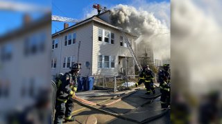 Firefighters battling a blaze at an unoccupied home in Boston's Roslindale neighborhood on Saturday, Jan. 15, 2022.