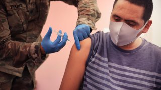 Maryland National Guard Specialist James Truong (L) administers a Moderna coronavirus vaccine at CASA de Maryland’s Wheaton Welcome Center on May 21, 2021 in Wheaton, Maryland.