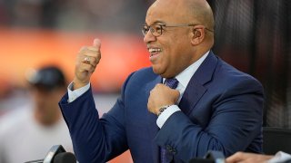 NBC broadcaster Mike Tirico motions to fans before the NFL Super Bowl 56 football game between the Los Angeles Rams and the Cincinnati Bengals, Sunday, Feb. 13, 2022, in Inglewood, Calif.