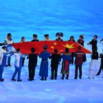 Performers symbolizing the 56 ethnic groups of China carries the national flag during the opening ceremony of the Beijing 2022 Winter Olympic Games in Beijing, Feb. 4, 2022.