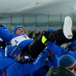 Team members toss gold medallist Quentin Fillon Maillet of Team France as they celebrate on the podium