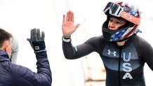 Kaillie Humphries of Team United States gives out a high five after finishing the Women's Monobob Bobsleigh Heat 3 on day 10 of 2022 Winter Olympics at National Sliding Centre on Feb. 14, 2022, in Yanqing, China.