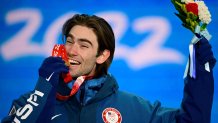 Gold medallist Alexander Hall bites on his medal won from the men's freeski slopestyle event of the 2022 Winter Olympic Games, in Zhangjiakou, China, Feb. 16, 2022.