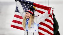 Bronze medallist, Jessie Diggins of Team USA celebrates with a flag during the Women's Cross-Country Sprint Free Final flower ceremony
