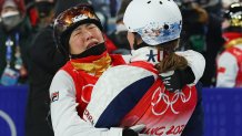 Gold medallist Xu Mengtao of Team China is embraced by Ashley Caldwell of Team United States