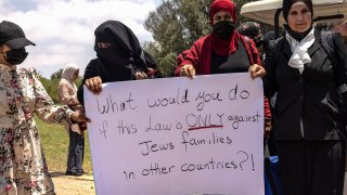 Israeli Arab women hold a sign during a protest