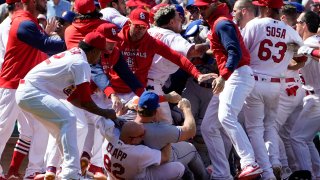 New York Mets' Pete Alonso is taken to the ground by St. Louis Cardinals first base coach Stubby Clapp (82) and Alonso's jersey is grabbed by Cardinals relief pitcher Genesis Cabrera, left, as benches clear during a scuffle