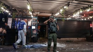 Israeli police inspect the scene of a shooting attack In Tel Aviv, Israel, Thursday, April 7, 2022. Israeli police say several people were wounded in a shooting in central Tel Aviv. The shooting on Thursday evening occurred in a crowded area with several bars and restaurants.