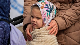 A refugee child waits in a line after fleeing the war from neighboring Ukraine at the border crossing in Medyka, southeastern Poland, Sunday, April 10, 2022.