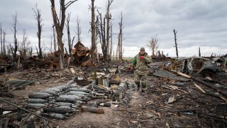 An interior ministry sapper collects unexploded shell, grenades and other devices in Hostomel, close to Kyiv, Ukraine, Monday, April 18, 2022.