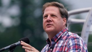 FILE— Republican New Hampshire Gov. Chris Sununu addresses fans at a NASCAR Cup Series auto race, July 18, 2021, in Loudon, N.H.