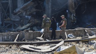 Ukrainian investigators work near a destroyed building on the outskirts of Odesa, Ukraine, Tuesday, May 10, 2022. The Ukrainian military said Russian forces fired seven missiles a day earlier from the air at the crucial Black Sea port of Odesa, hitting a shopping center and a warehouse.