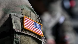 A US flag is pictured on a soldier's uniform