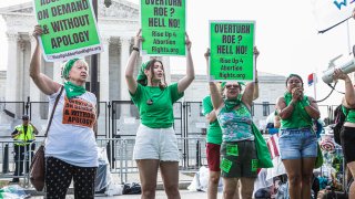 Protesters hold signs during a ShutDownDC demonstration outside the US Supreme Court in Washington, D.C., US, on Monday, June 13, 2022.