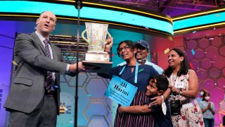 Harini Logan, 14, from San Antonio, Texas, celebrates winning the Scripps National Spelling Bee with Scripps CEO Adam Symson, left, and family stage Thursday, June 2, 2022, in Oxon Hill, Md.