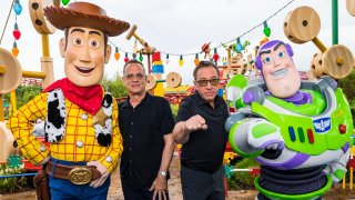 Tom Hanks and Tim Allen stand in between their characters Woody and Buzz