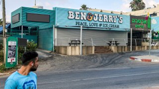 A man walks past a closed "Ben & Jerry's" ice-cream shop in the Israeli city of Yavne
