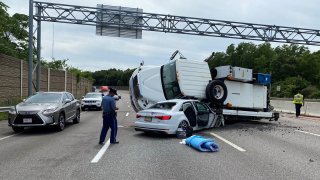A truck crashed onto a car on Massachusetts Route 128 in Wellesley on Tuesday, July 26, 2022.
