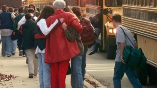 FILE - Students arriving at Heath High School in West Paducah, Ky., embrace an unidentified adult on Tuesday, Dec. 2, 1997,