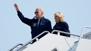 President Joe Biden waves as he stands at the top of the steps of Air Force One