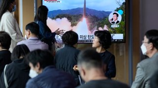 People watch a news program showing a file image of a missile launch by North Korea at the Seoul Railway Station in Seoul, South Korea
