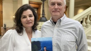 Dana and John Pope pose with a photo of their son Ethan