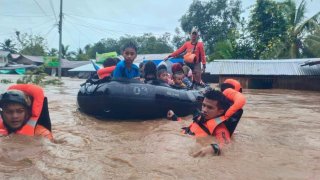 In this photo provided by the Philippine Coast Guard, rescuers use boats to evacuate residents from flooded areas due to Tropical Storm Nalgae