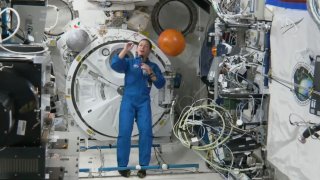 In this image from video made available by NASA, astronaut Nicole Mann shows her dreamcatcher during an interview on Oct. 19, 2022.