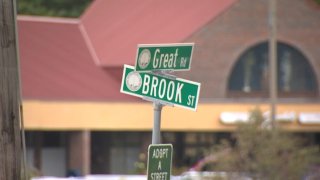 green and white street signs at an intersection read "Great Road" and "Brook Street"